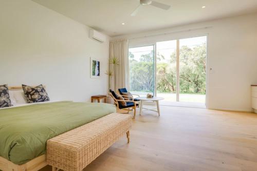 a bedroom with a bed and a table and a window at Ideally Located Modern Studio Apartment in Dunsborough