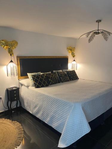 a bedroom with a large bed with two lights on it at Magic Garden Luxury Pent-house in Bello