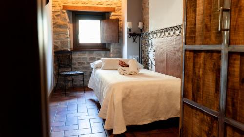 a bedroom with a bed with two pillows on it at Hotel El Cerco in Puente la Reina