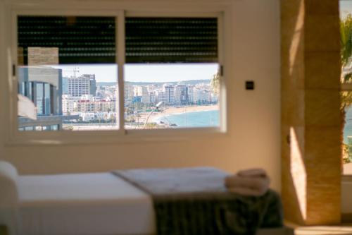 a bedroom with a window with a view of the beach at villa assalam Tanger in Tangier