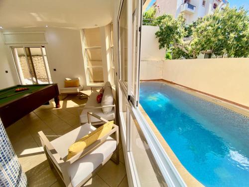 a swimming pool in a living room with a pool table at villa assalam Tanger in Tangier