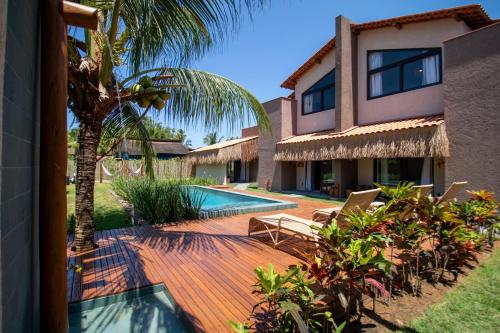 a house with a swimming pool and a palm tree at Kokoye Boutique Hotel in Pôrto de Pedras