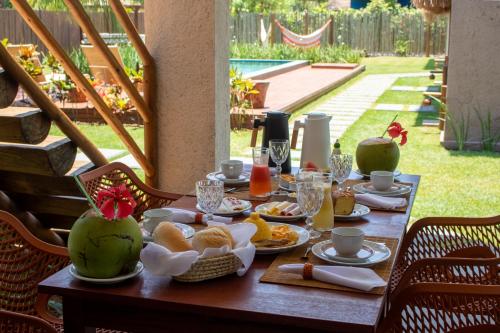 a wooden table with breakfast food on it at Kokoye Boutique Hotel in Pôrto de Pedras