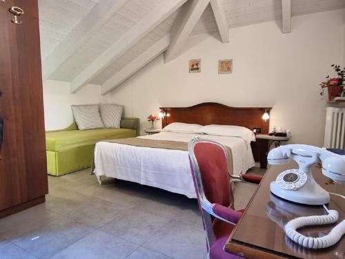 ein Schlafzimmer mit einem Bett, einem Schreibtisch und einem Tisch in der Unterkunft Hotel Charly in Mailand