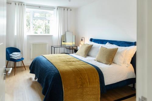 Un dormitorio con una cama azul y blanca y una ventana. en Modern Flat In Penge - 3 person, en Elmers End