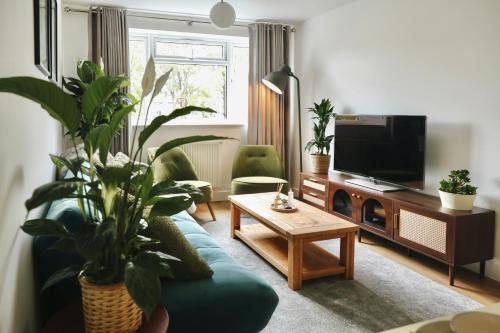 a living room with a blue couch and a tv at Modern Flat In Penge - 3 person in Elmers End