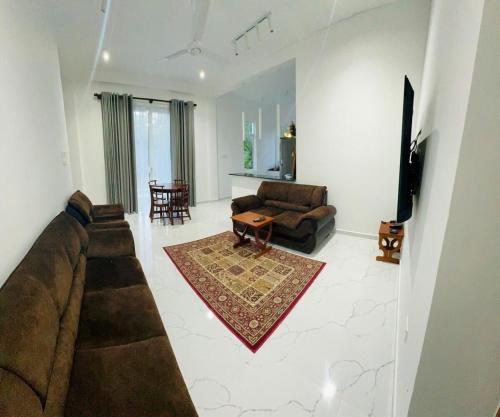 een woonkamer met een bank en een tv bij Joalis Villa Polhena Ltd in Matara