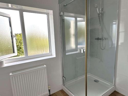 un bagno con doccia con porta in vetro di SALTKETTLE - Blakeney a Blakeney