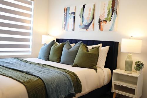 a bedroom with a bed with blue and white pillows at Seton 4BR Family Home King Bed Near Hospital in Calgary