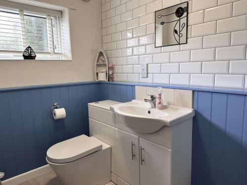 une salle de bain avec des toilettes blanches et un lavabo dans l'établissement COSY COTTAGE - Wells-next-the-Sea, à Wells-next-the-Sea