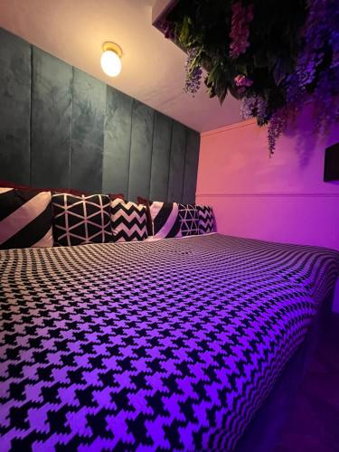 - une chambre avec un lit à éclairage violet dans l'établissement Manchester's ONLY themed slumber party suite for 8 with makeup room, à Manchester