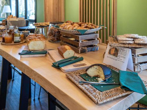a table with various types of bread on it at Mercure Niort Marais Poitevin in Niort