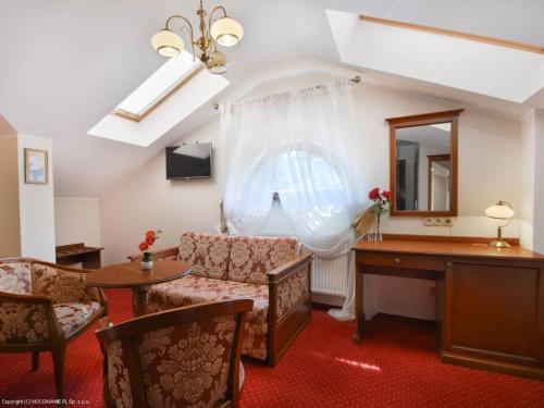 a living room with a couch and a desk and a mirror at Dworek Vesaria in Lublin