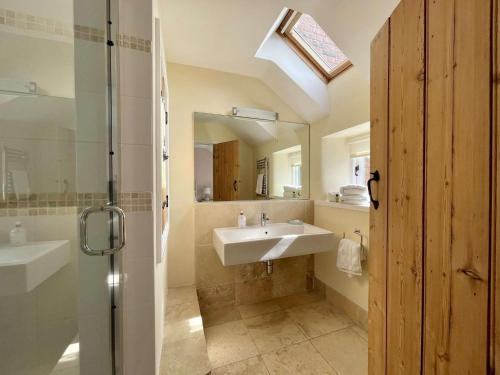 a bathroom with a sink and a mirror at Plum Tree Cottage, Burnham Market By Together Travel in Burnham Market