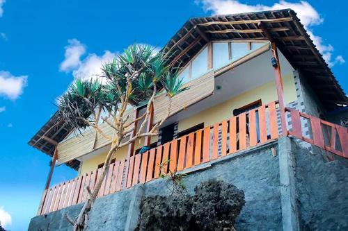 une maison dotée d'un balcon avec des palmiers. dans l'établissement Villa Happy Family, à Pulau Kukup
