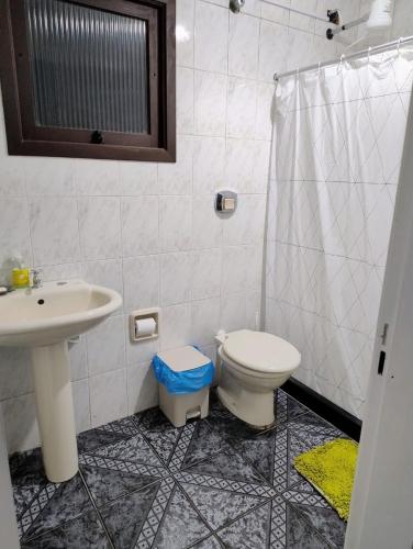 a bathroom with a toilet and a sink at Apartamento térreo Torres centro in Torres