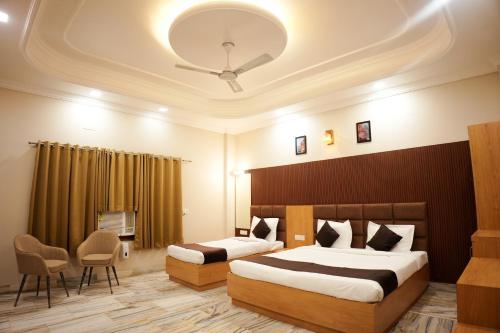 a hotel room with two beds and a table and chairs at Satguru Villa in Varanasi