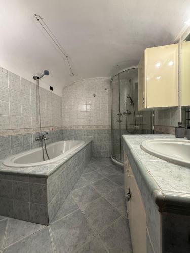 a bathroom with two sinks and a bath tub at Living Adua Centro in Tortona