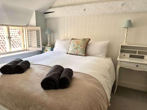 una camera da letto con un letto grande con asciugamani sopra di WELL COTTAGE - Salthouse a Salthouse