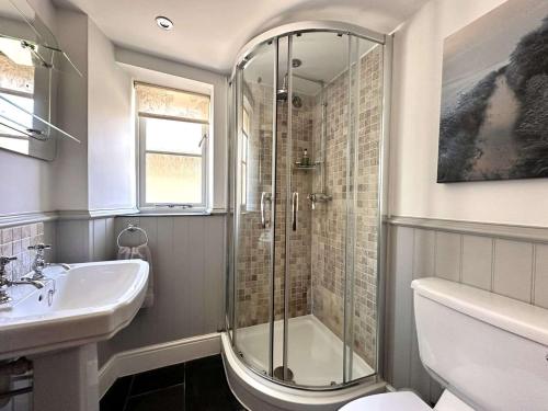 un bagno con doccia e lavandino di WELL COTTAGE - Salthouse a Salthouse