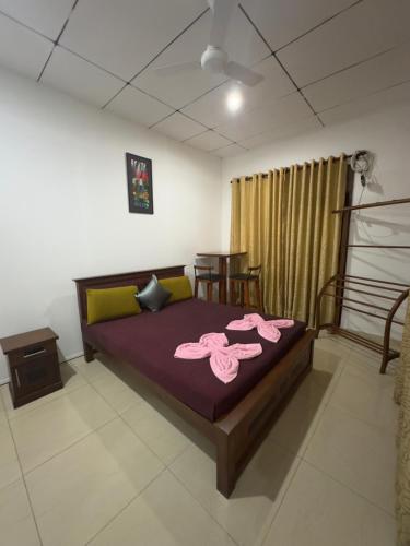 a bedroom with a bed with pink towels on it at Solace More Hotel - Battaramulla in Sri Jayewardenepura Kotte