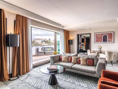 a living room with a couch and a large window at Sofitel Lisbon Liberdade in Lisbon