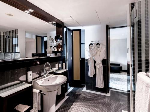 a bathroom with a sink and a toilet and a mirror at Sofitel Lisbon Liberdade in Lisbon