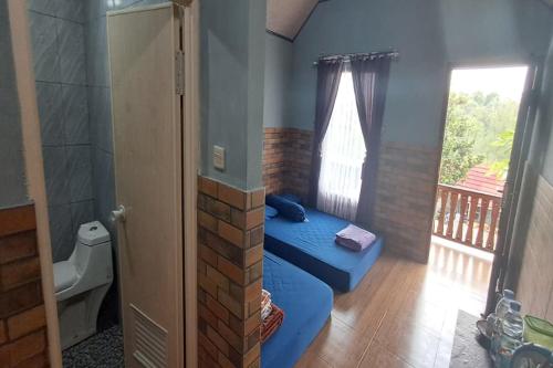 une chambre avec un lit bleu dans une pièce avec une fenêtre dans l'établissement Villa Happy Family, à Pulau Kukup