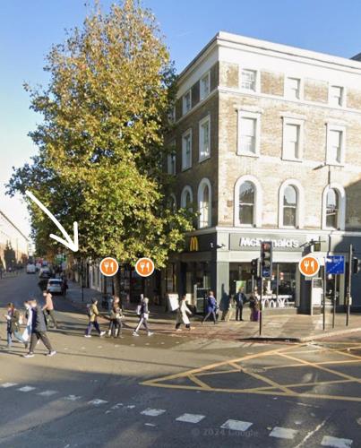 a group of people crossing a street in front of a building at Kings cross station 1 Bed flat for 4 in London