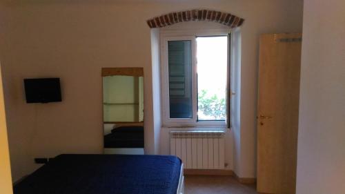 レ・グラツィエにあるAppartamento da Annamariaのベッドルーム1室(ベッド1台、窓、鏡付)