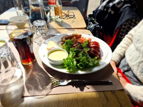 a plate of food on a table with a salad at ibis Vesoul in Vesoul