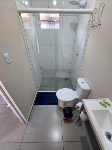 a bathroom with a shower with a toilet and a sink at Studio Cataratas com garagem e ar condicionado in Foz do Iguaçu