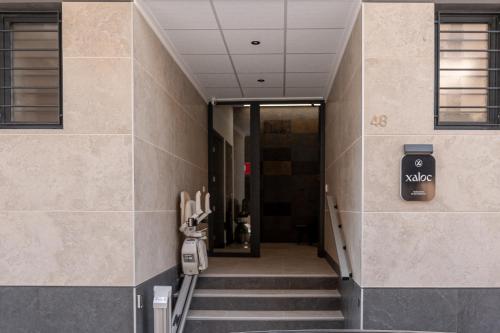 a hallway of a building with stairs and a sign on the wall at Xaloc Habitaciones in Santa Pola