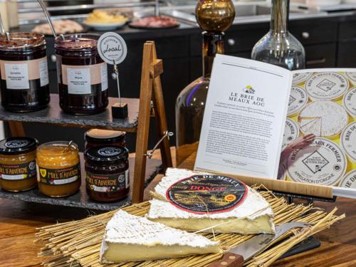 Una mesa con algo de comida y tarros de miel. en Mercure Paris La Défense, en Courbevoie