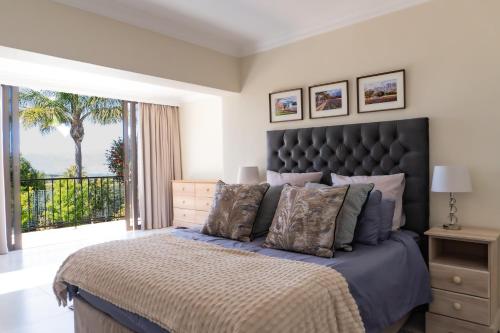 een slaapkamer met een groot bed met een groot raam bij Begonias Eden in Helderberg College