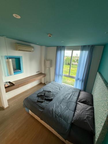 une chambre avec un grand lit et une fenêtre dans l'établissement Atlantis Condo Resort GP, à Jomtien Beach