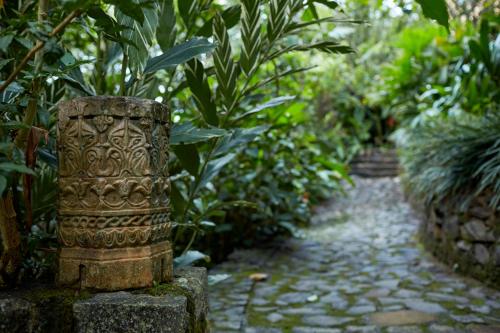 a stone pillar in a garden with plants at Bamboo Villa Kandy in Digana