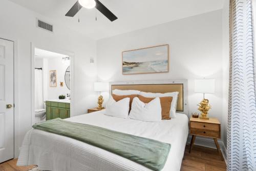Un dormitorio con una gran cama blanca con una manta verde. en Laketown Wharf 114, en Panama City Beach