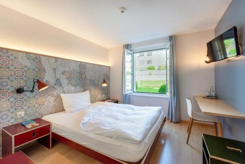 a hotel room with a bed and a window at Bären Self Check-in Hotel in Solothurn