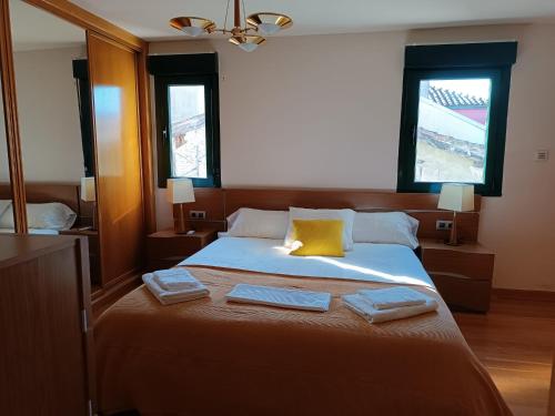 a bedroom with a large bed with two towels on it at Ático dúplex en Plaza de Trascorrales in Oviedo