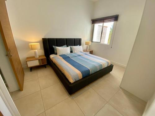a bedroom with a bed and two lamps on tables at Seaside Escape with Breathtaking View in Grand Gaube