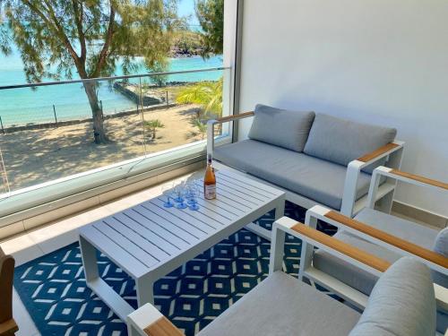 a living room with a couch and a table and a window at Seaside Escape with Breathtaking View in Grand Gaube