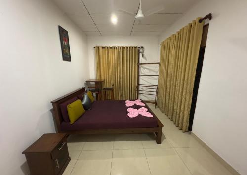 a small room with a bed with pink flowers on it at Solace More Hotel - Battaramulla in Sri Jayewardenepura Kotte