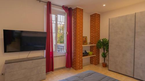 a living room with red curtains and a flat screen tv at Appartamento don orione in Tortona