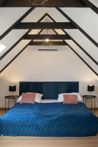 a bedroom with a blue bed with two night stands at Royal Rooms in Gdańsk