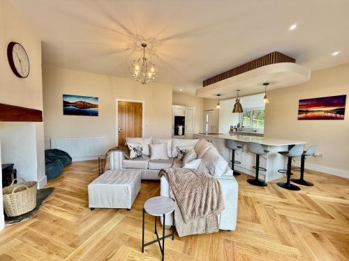 a living room with a couch and a table at Jaytrees, Keswick - Luxury bungalow with hot tub in Keswick