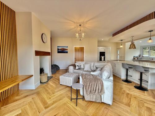 a living room with a couch and a kitchen at Jaytrees, Keswick - Luxury bungalow with hot tub in Keswick