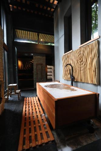 a large wooden tub in a room with a fireplace at Zero Zero Treehouse in Coleford