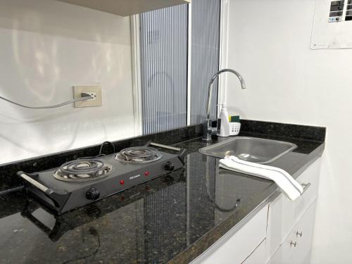 a kitchen with a stove and a sink at Casa 106 - Apartaestudios in Cali