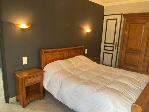 a bedroom with a white bed and two wooden cabinets at Maison de vacances in Ramous